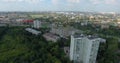 An aerial view of a sunny urbanscape among green trees