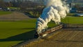 Aerial View at Sunrise of a Steam Passenger Train Approaching Blowing A Lot of Smoke