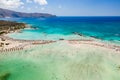 Aerial view of sunshades and umbrellas on a narrow sandy beach surrounded by shallow lagoons Elafonisso Beach, Crete, Greece Royalty Free Stock Photo