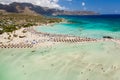 Aerial view of sunshades and umbrellas on a narrow sandy beach surrounded by shallow lagoons Elafonisso Beach, Crete, Greece Royalty Free Stock Photo