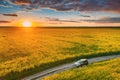 Aerial View. Sunshine At Sunrise Bright Dramatic Sky Above Agricultural Landscape With Flowering Blooming Oilseed Field Royalty Free Stock Photo