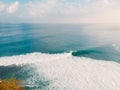 Aerial view of surf spot with surfers and big barrel wave in ocean.