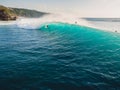 Aerial view of surfer at barrel wave. Blue waves and surfers in Bali