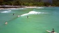 Aerial view surfer beginners gambol on foamy waves