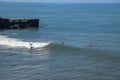 Aerial view of surfer on blue surface of Indian ocean. Riding the waves. Batu Bolong beach on the rocky coast of Bali island,