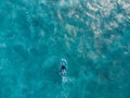 Aerial view of surfer on surfboard in blue ocean with foam Royalty Free Stock Photo