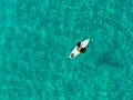 Aerial view of surfers waiting, paddling and enjoying waves in a beautiful blue water Royalty Free Stock Photo