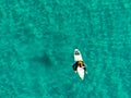 Aerial view of surfers waiting, paddling and enjoying waves in a beautiful blue water Royalty Free Stock Photo