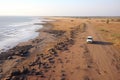 Aerial view of suv car driving on the seashore sands, scenic view of off-road adventure