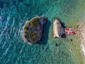 Aerial view of Sveti Nicola, Budva island, Montenegro. Hawaii beach, umbrellas and bathers and crystal clear waters