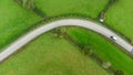 Aerial view taken from above of a sharp bend in a road with Chevron warning signs.