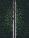 Aerial view taken by drone of a car driving on a forest road in autumn Royalty Free Stock Photo