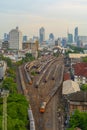 Aerial view of Thai local old classic train or tram on railway in Hua Lamphong terminal station with skyscraper buildings in urban Royalty Free Stock Photo