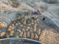 Aerial view of three multi-colored dump tip trucks unloading in Royalty Free Stock Photo