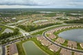 Aerial view of tightly packed homes in Florida closed living clubs with lake water in the middle. Family houses as