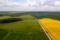 Aerial view to countryside with road, green and yellow agricultural fields, forests Royalty Free Stock Photo