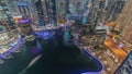 Aerial view to Dubai marina skyscrapers around canal with floating boats night timelapse Royalty Free Stock Photo