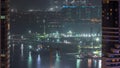 Aerial view to Dubai marina skyscrapers with construction site and Palm Jumeirah Island on background night timelapse. Royalty Free Stock Photo