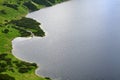 Aerial view to lake and surrounded green land covered with grass