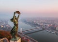Aerial view to the Statue of Liberty with Elisabeth Bridge and River Danube taken from Gellert Hill on sunrise in fog in Royalty Free Stock Photo