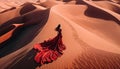 Aerial view to woman in billowing red dress in desert sand rear view, beautiful desert scape Royalty Free Stock Photo