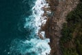 Aerial view Top down seashore big wave crashing on rock cliff Beautiful dark sea surface in sunny day summer background Royalty Free Stock Photo