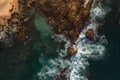 Aerial view Top down seashore big wave crashing on rock cliff Beautiful dark sea surface in sunny day summer background Royalty Free Stock Photo