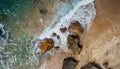 Aerial view top seashore, rocky coast, waves crashing on rock cliff. Blue ocean surface sunny summer Royalty Free Stock Photo