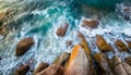 Aerial view top seashore, rocky coast, waves crashing on rock cliff. Blue ocean surface sunny summer Royalty Free Stock Photo