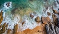 Aerial view top seashore, rocky coast, waves crashing on rock cliff. Blue ocean surface sunny summer Royalty Free Stock Photo