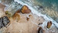 Aerial view top seashore, rocky coast, waves crashing on rock cliff. Blue ocean surface sunny summer Royalty Free Stock Photo