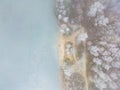 Aerial view or top view of winter forest lake, showing the ice on the lake and the pine trees with snow covered. Winter Royalty Free Stock Photo