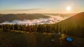 Aerial view of tourist camping tents on mountain campsite at bright sunny evening. Active tourism and hiking concept