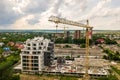 Aerial view of tower lifting crane and concrete frame of tall apartment residential building under construction in a city. Urban Royalty Free Stock Photo