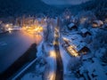 Aerial view of town in snow, road, forest, lake and houses Royalty Free Stock Photo