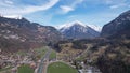 Aerial view of a town surrounded by green fields and snow-capped mountains. Switzerland. Royalty Free Stock Photo