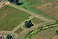 Aerial View of a tractor cutting the green grass field in a farm. Royalty Free Stock Photo