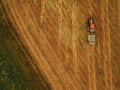 Aerial view of tractor making hay bale rolls in field