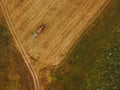 Aerial view of tractor making hay bale rolls in field