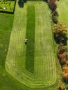 Top down aerial view, of a neatly moved green grass field, tractor mowing the field in circles from outside in Royalty Free Stock Photo