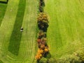 Aerial view of freshly mowed green gras field and a tractor finishing mowing a field Royalty Free Stock Photo