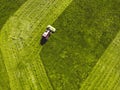 Aerial view tractor mowing a green grass field from outside in Royalty Free Stock Photo