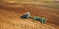 Aerial View. Tractor Plowing Field. Beginning Of Agricultural Spring Season. Cultivator Pulled By A Tractor In