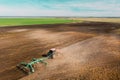 Aerial View. Tractor Plowing Field. Beginning Of Agricultural Spring Season. Cultivator Pulled By A Tractor In