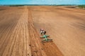 Aerial View. Tractor Plowing Field In Spring Season. Beginning Of Agricultural Spring Season. Cultivator Pulled By A