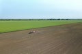 Aerial view Tractor spraying chemicals on the large field.