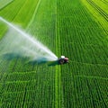 Aerial view tractor spraying the chemicals on the large green