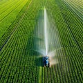 Aerial View of Tractor Spraying Pesticides on Green Soybean Plantation at Sunset Drone View