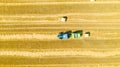 Aerial view of tractor tow trailed bale machine to collect straw from harvested field