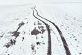 Aerial view of tractor tyre tracks in snowy field in winter morning